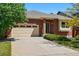 Classic brick home with a two-car garage and neatly maintained landscaping under a clear blue sky at 25077 E Canal Pl, Aurora, CO 80018