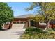Charming brick home with a well-manicured lawn and a two-car garage on a sunny day at 25077 E Canal Pl, Aurora, CO 80018