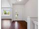 Bright foyer features hardwood floors, a white front door, and a view into the adjacent living space at 25077 E Canal Pl, Aurora, CO 80018