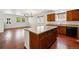 Open-concept kitchen with hardwood floors, a center island, and seamless flow to living space at 25077 E Canal Pl, Aurora, CO 80018