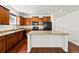 Functional kitchen with wood cabinets, black appliances, a center island, and hardwood floors at 25077 E Canal Pl, Aurora, CO 80018