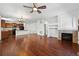 Open-concept living space with hardwood floors flowing into a kitchen with a breakfast bar and fireplace at 25077 E Canal Pl, Aurora, CO 80018