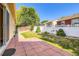 Landscaped backyard featuring a brick patio, lawn, shrubs, and fenced perimeter for privacy at 5037 Pelican St, Brighton, CO 80601