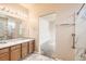 Bathroom featuring double sinks, marble style tile, and a separate shower room at 5037 Pelican St, Brighton, CO 80601
