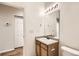 Bathroom featuring a single sink vanity, toilet, and a shower with glass doors at 5037 Pelican St, Brighton, CO 80601