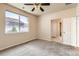 Well-lit bedroom with a large window, ceiling fan, and easy access to the bathroom at 5037 Pelican St, Brighton, CO 80601
