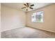 Bedroom with a ceiling fan and large window, featuring neutral walls and comfortable carpeting at 5037 Pelican St, Brighton, CO 80601