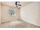 Neutral-toned bedroom with a ceiling fan and large window offering ample natural light at 5037 Pelican St, Brighton, CO 80601