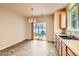 Bright dining area with tile floors, a modern light fixture, and sliding glass doors to the backyard at 5037 Pelican St, Brighton, CO 80601