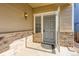 Inviting entryway featuring a stylish front door, stone accents, and a welcoming outdoor light fixture at 5037 Pelican St, Brighton, CO 80601