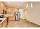 Bright kitchen featuring stainless steel appliances, warm wooden cabinetry, and tile flooring, creating a functional space at 5037 Pelican St, Brighton, CO 80601
