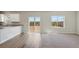 Open-concept living area with carpet and wood flooring plus large windows with natural light and backyard view at 7244 Arkansas St, Frederick, CO 80530