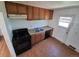 This kitchen features oak cabinets, black oven and dishwasher, and vinyl wood flooring at 1266 Del Mar Pkwy, Aurora, CO 80010