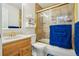 Bright bathroom with a tiled shower, single sink vanity, and a decorative mirror at 6462 E Bates Ave, Denver, CO 80222