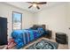 Vibrant bedroom featuring a patterned bedspread, dark wood accents, and a window with natural light at 6462 E Bates Ave, Denver, CO 80222