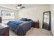 Comfortable bedroom with a ceiling fan, large window, neutral decor, and ample natural light at 6462 E Bates Ave, Denver, CO 80222