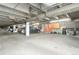 Parking garage showcasing exposed pipes, overhead lighting and parking spaces on a concrete floor at 6462 E Bates Ave, Denver, CO 80222