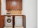 Functional laundry area with a side-by-side washer and dryer and cabinet storage at 6462 E Bates Ave, Denver, CO 80222