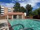Community swimming pool with clear blue water and lounge area surrounded by trees at 6462 E Bates Ave, Denver, CO 80222