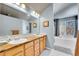 Main bathroom featuring dual sinks, soaking tub, and natural lighting at 5520 Morgan Way, Frederick, CO 80504