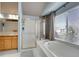 Bright bathroom offers natural lighting, dual shower and tub, and white tiled floors at 5520 Morgan Way, Frederick, CO 80504