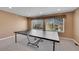 Bright game room with large windows, neutral carpeting, and a ping pong table for Gathering fun at 5520 Morgan Way, Frederick, CO 80504