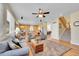 Cozy living room with hardwood floors, a ceiling fan, and an open view to the kitchen, ideal for relaxation at 5520 Morgan Way, Frederick, CO 80504