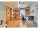 Bright office with hardwood floors, built-in bookshelves, and a large window at 5520 Morgan Way, Frederick, CO 80504