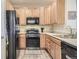 Efficient kitchen with wood cabinets and stainless steel appliances at 10437 W Hampden Ave # 202, Lakewood, CO 80227