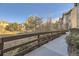 Paved walkway with a wooden railing overlooking a natural area at 10437 W Hampden Ave # 202, Lakewood, CO 80227