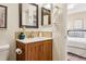 Bathroom with wood vanity, white countertop, framed mirror, and toilet with a view of the bedroom at 1825 Kendall St # 107, Lakewood, CO 80214