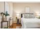 Cozy bedroom showcasing a stylish accent wall, neutral tones, hardwood floors, and natural light at 1825 Kendall St # 107, Lakewood, CO 80214