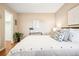 Well-lit bedroom featuring neutral tones, modern decor, a large bed, and a glimpse into the closet with nice flooring at 1825 Kendall St # 107, Lakewood, CO 80214