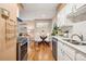 Bright kitchen with stainless steel appliances, white cabinets, a view into the living area, and hardwood flooring at 1825 Kendall St # 107, Lakewood, CO 80214