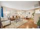 Cozy living room features a leather sofa, area rug, and adjacent dining area with wood floors at 1825 Kendall St # 107, Lakewood, CO 80214