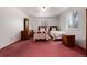 Simple bedroom with twin beds, wood furniture, and pink carpeting at 6926 S Saulsbury St, Littleton, CO 80128