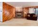 Brick fireplace in living room with wood paneling at 6926 S Saulsbury St, Littleton, CO 80128