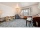 Living room boasts a bay window, comfy seating and a vintage organ at 6926 S Saulsbury St, Littleton, CO 80128