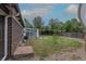 Backyard features a screen house, gravel perimeter, partial fencing, and sparse grass at 7042 W 76Th Ave, Arvada, CO 80003
