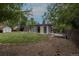 This backyard features a home, shed, mature trees and a mix of gravel and grass at 7042 W 76Th Ave, Arvada, CO 80003