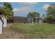 This backyard shows a home, grass, gravel, mature trees, and shed on the property at 7042 W 76Th Ave, Arvada, CO 80003