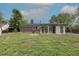 This backyard shows a home, grass, gravel, mature trees, and shed on the property at 7042 W 76Th Ave, Arvada, CO 80003