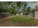 View of the backyard with grass and gravel, mature trees, and a shed on the property at 7042 W 76Th Ave, Arvada, CO 80003