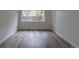 This bedroom features wood-look floors, fresh paint, and ample natural light from the window at 7042 W 76Th Ave, Arvada, CO 80003