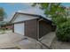 Side view of a 2-car garage, showing brick siding and a well-maintained concrete driveway at 7042 W 76Th Ave, Arvada, CO 80003