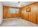 Bedroom featuring wood paneled walls, carpet and a window at 423 Empire St, Aurora, CO 80010