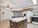Bright kitchen layout featuring an island with seating, tile floors, and a view into the living area at 423 Empire St, Aurora, CO 80010