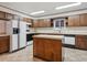 A well-lit kitchen boasts wooden cabinets, an island with white countertops, and modern appliances at 423 Empire St, Aurora, CO 80010