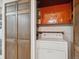 The laundry room features a stacked washer and dryer with wood cabinet space and bi-fold doors at 423 Empire St, Aurora, CO 80010