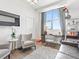 A sunlit living room with a view featuring a work station and grey velvet furniture at 2001 Lincoln St # 1822, Denver, CO 80202
